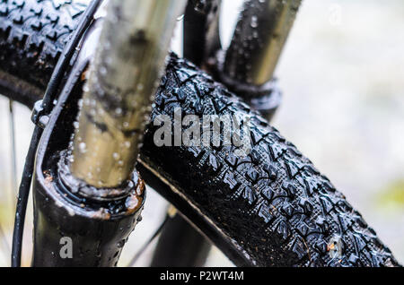 Waschen schmutziger Mountainbike Federgabel Nach dem Reiten bei schlechtem Wetter. Nässe, Schmutz und Öl Flecken an den Beinen der Mountainbike Gabel Stockfoto