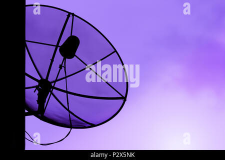 Satellitenschüssel für Kommunikation Broadcast auf dem Dach mit Sonnenuntergang Himmel, Dämmerung, silhouette lila Hintergrund, Lichteffekt, mit kopieren. Stockfoto