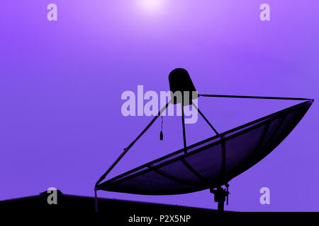 Satellitenschüssel für Kommunikation Broadcast auf dem Dach mit Sonnenuntergang Himmel, Dämmerung, silhouette lila Hintergrund, Lichteffekt, mit kopieren. Stockfoto