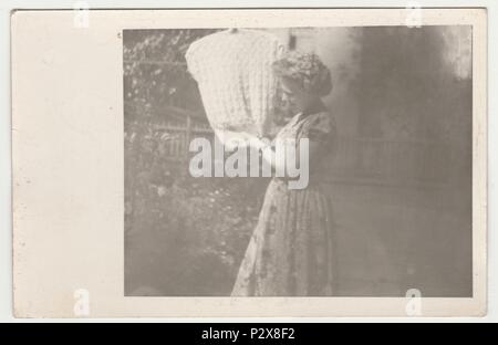 Die tschechoslowakische SOZIALISTISCHE REPUBLIK - AUGUST 1958: Vintage Foto zeigt eine junge Frau hängt ein wolliges Weste auf einer Wäscheleine. Retro Schwarz/Weiß-Fotografie. Stockfoto