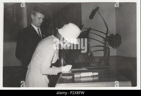 Die tschechoslowakische SOZIALISTISCHE REPUBLIK - circa 1970 s: Vintage Foto zeigt eine Braut Signaturen die Heiratsurkunde. Retro Schwarz/Weiß-Fotografie. Stockfoto