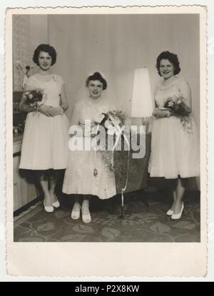 Die tschechoslowakische SOZIALISTISCHE REPUBLIK - um 1960 s: Vintage Foto zeigt eine Braut mit Brautjungfern. Braut trägt eine weiche Decke und hält calla Blumen (Bouquet). Retro Schwarz/Weiß-Fotografie. Stockfoto