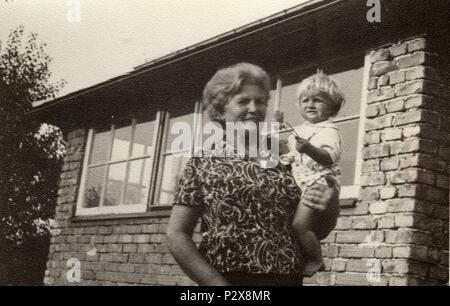 Die tschechoslowakische SOZIALISTISCHE REPUBLIK - circa 1950s: Vintage Foto zeigt Großmutter hält ein kleines Baby. Retro Schwarz/Weiß-Fotografie Stockfoto