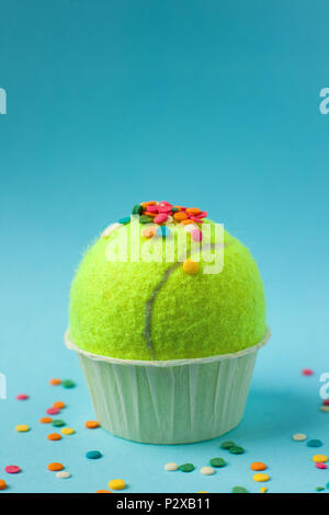 Form für Cupcake, Tennis ball und Rainbow Süßwaren Pulver um auf blauem Hintergrund, minimale kreative Sport oder Gebäck Idee. Flach, Ansicht von oben. Stockfoto