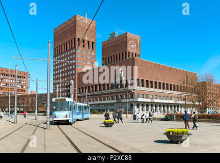 OSLO, Norwegen - 12 April 2010: Menschen und blaue Straßenbahn in der Nähe des Rathaus Stockfoto