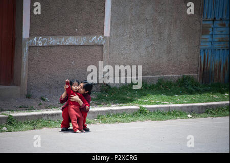 Eine Mutter ihr Kind halten und winkte zum Zug, wie sie Reisen von Cusco nach Puno Titicacasee in Peru Rail in Peru Südamerika Stockfoto