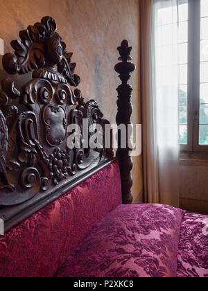 Torreglia, Italien, 26. Mai 2018: antikes Himmelbett mit geschnitzten Kopfteilen in der Villa dei Vescovi, einem Venezianischen Renaissance Villa. Currentl Stockfoto
