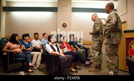 Brooke Army Medical Center Commander Brig. Gen. Jeffrey Johnson dank jungen Freiwilligen als Befehl Sgt. Maj. Albert Besatzungen an schaut während einer Anerkennung Zeremonie an BAMC, Aug 2, 2016. (U.S. Armee Foto von James Camillocci/Freigegeben) Stockfoto