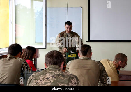 YAVORIV, Ukraine-SPC. Nicholas Jones, eine Mitteilung Spezialist mit 6 Squadron, 8th Cavalry Regiment, 2 Infantry Brigade Combat Team, 3rd Infantry Division zeigt Ukrainische Soldaten, wie Sie eine hohe Frequenz radio Set (RT-1694) während einer Kommunikation Klasse, 6. August 2016. Der Mustang Soldaten gezeigt, wie die Radios betrieben werden, so dass die Ukrainer ein gutes Verständnis von, wie es funktioniert. Soldaten von 6-8 Cav sind hier in Unterstützung des Gemeinsamen multinationalen Ausbildung Group-Ukraine. JMTG-U ist verantwortlich für die Ausbildung von ukrainischen Land Kräfte und der Aufbau eines Teams der Ukrainischen cadr Stockfoto