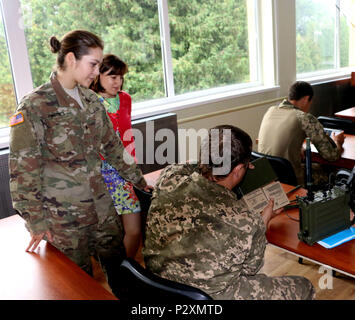 YAVORIV, Ukraine-SPC. Herbst Viruet, eine Mitteilung Spezialist mit 6 Squadron, 8th Cavalry Regiment, 2 Infantry Brigade Combat Team, 3rd Infantry Division bietet eine ukrainische Soldaten eine Schritt für Schritt Anleitung für eine hohe Frequenz radio (RT-1694) zusammen während einer Kommunikation Klasse, 6. August 2016. Soldaten von 6-8 Cav sind hier in Unterstützung des Gemeinsamen multinationalen Ausbildung Group-Ukraine. JMTG-U ist verantwortlich für die Ausbildung von ukrainischen Land Kräfte und der Aufbau eines Teams der Ukrainischen Kader, wer letztendlich die Verantwortung übernehmen. Die Ausbildung ist so konzipiert, beklagten zu verstärken Stockfoto