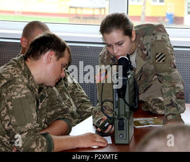 YAVORIV, Ukraine-SPC. Herbst Viruet, eine Mitteilung Spezialist mit 6 Squadron, 8th Cavalry Regiment, 2 Infantry Brigade Combat Team, 3rd Infantry Division zeigt eine ukrainische Soldaten wie eine Frequenz auf eine hohe Frequenz Radio zu laden (RT-1694) während einer Kommunikation Klasse, 6. August 2016. Soldaten von 6-8 Cav sind hier in Unterstützung des Gemeinsamen multinationalen Ausbildung Group-Ukraine. JMTG-U ist verantwortlich für die Ausbildung von ukrainischen Land Kräfte und der Aufbau eines Teams der Ukrainischen Kader, wer letztendlich die Verantwortung übernehmen. Die Ausbildung ist so konzipiert, dass defensive Fähigkeiten der Ukra ausgeliefert zu verstärken Stockfoto