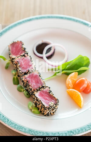 Thunfisch mit Sesam mit grünem Salat auf weiße Platte Stockfoto