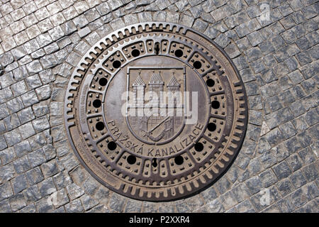 Ein kanaldeckel auf einer gepflasterten Straße im historischen Zentrum von Prag, Tschechische Republik. Die Inschrift bedeutet Prager Kanalisation. Stockfoto