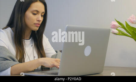 Sorgen junge Geschäftsfrau, die Sie auf Ihrem Laptop und schließlich lächelnd Stockfoto