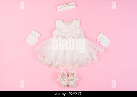 Schönes baby Kleid mit füßlinge und Handschuhe auf einem rosa Hintergrund isoliert Stockfoto