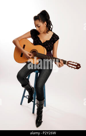 Junge Frau spielt die akustische Gitarre Stockfoto