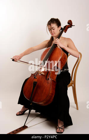 Junge Frau in concert Kleid spielt das Cello Stockfoto