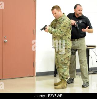 Sgt. Eric Urbanski eine Chemische, biologische, radiologische und nukleare noncommissioned Officer von HHC, 416Th Theater Ingenieur Befehl (TEC), links, und FBI Special Agent Michael Culloton, verschiedene Techniken, die einen sicheren und unmittelbaren Bedrohung Begegnungen zu ermöglichen, während der aktiven shooter Ausbildung an der 416th TEC Hauptsitz demonstrieren, in Darien, Illinois die Ausbildung zur Verfügung gestellt von Special Agent Culloton gab Soldaten Tools zu reagieren und sich in einer aktiven shooter Situation, Aug 6, 2016 Schützen. (U.S. Armee Foto von SPC. Brianna Saville / freigegeben) Stockfoto