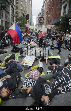 Meist junge philippinische Amerikaner protestieren die diktatorischen starker Mann Taktiken der Präsident Duterte des Phiippines und eine momentane 'Die' vor der VIP-Anzeige steht an der Philippine Independence Day Parade in New York City. Stockfoto