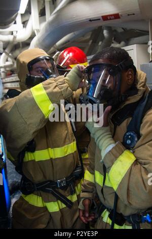 160806-N-CL 027-207 Golf von Aden (Aug. 6, 2016) der Bootsmann Mate 2. Klasse Alexander Mohney, von Ashtabula, Ohio, hilft Bootsmann Mate 3. Klasse Devonte Moore, aus Detroit, Mich., Don ein umluftunabhängiges Atemschutzgerät Maske während ein General Quarters bohren an Bord der geführte Anti-raketen-Zerstörer USS Mason (DDG87). Mason, eingesetzt als Teil der Eisenhower Carrier Strike Group, unterstützt Maritime Security Operations und Theater Sicherheit Zusammenarbeit in den USA 5 Flotte Bereich der Operationen. (U.S. Marine Foto von Mass Communications Specialist 3. Klasse Janweb B. Lagazo/Freigegeben) Stockfoto