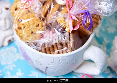 Geschenk Pakete mit Cookies mit hellen Bändern in einer großen Schale. Stockfoto