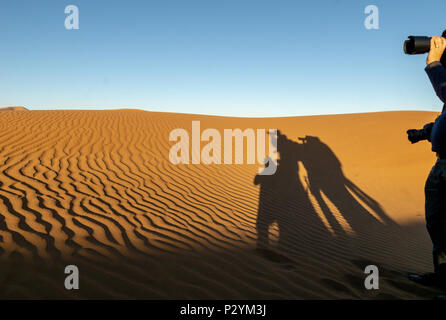 Schatten des Fotografen auf orange Dünen von Hidden Vlei, Sossusvlie Namibia wider Stockfoto