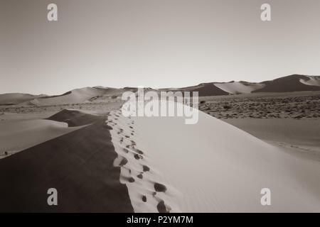 Fußabdrücke in hügeligen ridge Linien von Orange und rote Farbe Dünen von Hidden Vlei, Sossusvlie Namibia Stockfoto