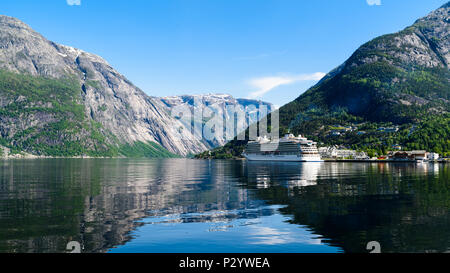 Das Dorf Eidfjord, Hordaland, Norwegen auf einer sehr ruhigen und sonnigen Tag. Ein Kreuzfahrtschiff ist außerhalb der kleinen Stadt in den Fjord und das surro günstig Stockfoto