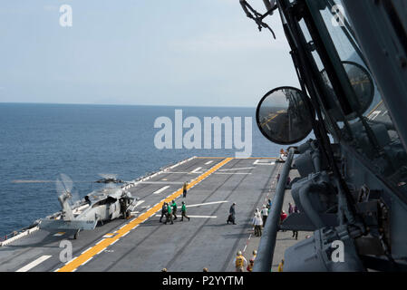 160812-N-NB 544-092 EAST CHINA SEA (Aug. 12, 2016) eine Abteilung Matrosen zugeordnet Amphibisches Schiff USS BONHOMME RICHARD (LHD6) Hilfe Besatzungsmitglieder Fracht von einem MH-60S Knighthawk entladen', 'bis zum Hubschrauber Meer Combat Squadron (HSC) 25 zugeordnet. HSC25 ist der Marine nur Vorwärts - bereitgestellt MH-60S expeditionary Squadron. Bonhomme Richard, dem Flaggschiff der Bonhomme Richard Expeditionary Strike Group, ist in den USA der 7. Flotte Bereich für Maßnahmen zur Erhöhung der Sicherheit und Stabilität in der Indo-Asia-Pazifik-Region. (U.S. Marine Foto von Mass Communication Specialist 2. Klasse Kyle Carlstr Stockfoto