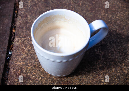 Detailansicht der Tasse mit Kaffee und Milch. Trinken espresso Konzept Bild. Makro-ansicht Cappuccino Kaffee mit Milch. Kaffeebecher serviert auf die rostigen t Stockfoto