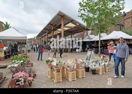 Blumenstand vor dem Altrincham Market, Greenwood Street, Trafford, mit Einkäufern auf dem regenerierten alten Marktplatz, einem geschäftstüchtigen Einzelhandelsziel Stockfoto
