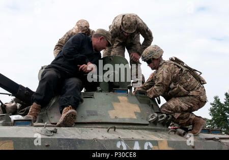 Us-Armee SPC. Michael Wilson, zur 6. Staffel zugeordnet, 8 Kavallerie Regiments, 2 Infantry Brigade Combat Team, 3rd Infantry Division, diskutiert die Bedeutung der Erhaltung der BMP-2-Schützenpanzer mit ukrainischen Soldaten vor der Durchführung einer Live-fire Übung als Teil der Gemeinsamen multinationalen Ausbildung Group-Ukraine an der internationalen Friedenssicherung und Security Center, Ukraine, 13.08.2016. Die gemeinsame Multinationale Ausbildung Group-Ukraine bietet US-Soldaten und spezielle Betriebspersonal Ukraine National Guard Einheiten in eine fortlaufende Anstrengung Ukr zu stärken zu trainieren Stockfoto