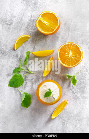 Leckere orange Eis in den Früchten auf Stein Hintergrund. Kalten Sommer Nachtisch. Ansicht von oben, flach Stockfoto