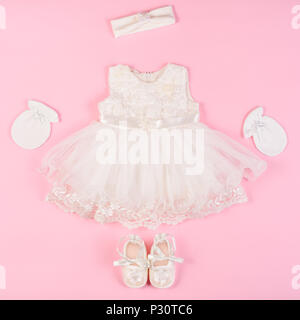 Schönes baby Kleid mit füßlinge und Handschuhe auf einem rosa Hintergrund isoliert Stockfoto