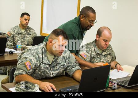 FORT MCCOY, Wis-National Guard Soldaten des 176. Finance Management Distanz, von Indianapolis, Ind, Anweisung von John Payne, (Mitte), dem stellvertretenden Direktor der Verteidigung militärischer Office von Fort Sam Houston, Texas. Soldaten aus der US-Armee Komponenten erfahren Sie, wie Sie zahlen Prozess live militärische Dokumente während der Teilnahme an Übung Diamond Sabre im August 2016. (U.S. Armee finden Foto von Sgt. Clinton Massey, im Broadcast Operations Loslösung) Stockfoto