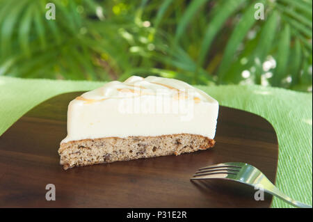 Stück Eistorte mit Vanilleeis auf bananenkuchen mit Karamell Swirl außerhalb in den Tropen Stockfoto