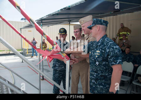 160826-N-WI 626-017 Santa Rita, Guam (26. August 2016) von links nach rechts, Cmdr. Lance Thompson, Commander, Submarine Squadron 15 Stellvertreter für Mission Bereitschaft; Lt.Cmdr. Jarrod Trant, Naval Submarine Training Center (NSTCP) Distanz (DET) Guam Offizier, Kapitän Michael Martin, NSTCP kommandierenden Offizier und Kapitän Jeffrey Grimes, gemeinsame Region Marianas Stabschef, öffnen Sie die neue Mobile Trainer 1000 u-boot Brandbekämpfung Trainer während ein Ribbon Cutting auf Polaris, Guam, 12.08.26. NSTCP det Guam bietet Schulungen für die vier Los Angeles-Klasse Angriffs-U-Boote von Stockfoto