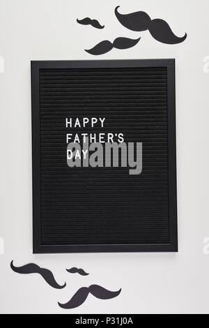 Schwarz mit weißem Kunststoff letterboard Briefe mit Zitat Happy Vatertag, auf weißem Hintergrund mit Schnurrbart. Stockfoto