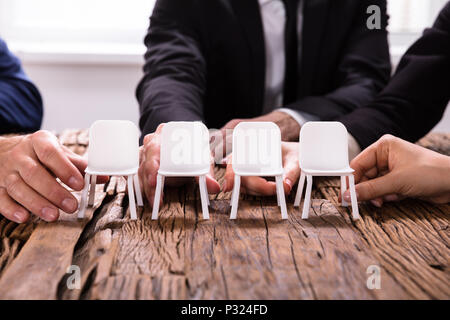 Nahaufnahme einer Unternehmer die Hände Stühle Anordnen in einer Zeile Stockfoto