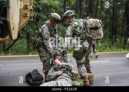 FORT MCCOY, Wis-US Army Reserve Soldaten, mit dem 397Th Engineering Bataillon von Eau Claire, Wis., ziehen Sie ein Opfer eines Mock am Straßenrand Angriff auf die Sicherheit. U.S. Army Reserve Medic, Pfc. Gage Theisen (rechts) verwaltet und Erster Hilfe bereitet Opfer für Medical Evacuation während eines combat Support Training übung 12.08.20, 2016 in Fort McCoy, Wis (U.S. Armee finden Foto von Sgt. Clinton Massey, im Broadcast Operations Loslösung) Stockfoto