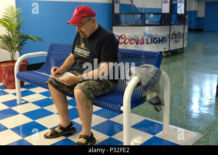 Ein Mann mittleren Alters seine Einsätze am Monmouth Park Sport Buch Kommissionierung Stockfoto