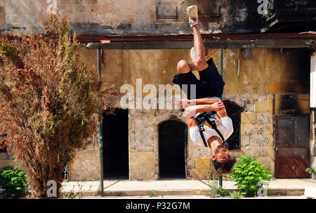 Aleppo, Syrien. 8. Juni 2018. Eine junge syrische parkour Player führt einen Backflip im weitgehend zerstörten Teil der Stadt Aleppo, nördliches Syrien, am 8. Juni 2018. Mit ihren atemberaubenden Flips und springen Stunts, einer Gruppe junger Syrer bringt wieder Leben in die zerstörte Teile von Aleppo Stadt mit ihrer elektrisierenden Parkour Leistung. Um mit der Funktion: Junge Syrer beleben das Leben in Ruinen der Altstadt von Aleppo mit elektrisierenden Parkour Leistung. Credit: Ammar Safarjalani/Xinhua/Alamy leben Nachrichten Stockfoto