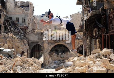 Aleppo, Syrien. 8. Juni 2018. Eine junge syrische parkour Player führt eine hohe backflip im weitgehend zerstörten Teil der Stadt Aleppo, nördliches Syrien, am 8. Juni 2018. Mit ihren atemberaubenden Flips und springen Stunts, einer Gruppe junger Syrer bringt wieder Leben in die zerstörte Teile von Aleppo Stadt mit ihrer elektrisierenden Parkour Leistung. Um mit der Funktion: Junge Syrer beleben das Leben in Ruinen der Altstadt von Aleppo mit elektrisierenden Parkour Leistung. Credit: Ammar Safarjalani/Xinhua/Alamy leben Nachrichten Stockfoto