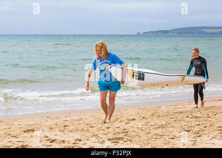 Branksome Chine, Poole, Dorset, Großbritannien. 17. Juni 2018. UK Wetter: breezy Tag am Strand in Branksome Chine, nicht davon abhalten, die Besucher zum Meer gehen. Frauen, die surfski Surf Ski. Credit: Carolyn Jenkins/Alamy leben Nachrichten Stockfoto