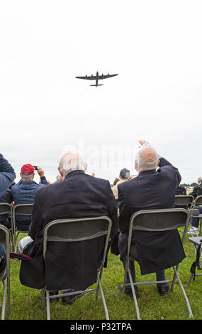 Weltkrieg zwei Veteranen winken zu einem vintage Royal Air Force Lancaster Bomber, wie es über dem Kopf an einem Veteranen feier Veranstaltung Halfpenny Green Airfield in England fliegt. Stockfoto