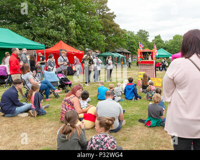 Warrington, Großbritannien, 17. Juni 2018 - eine Menschenmenge, die die Gemeinschaft Fundraiser und beobachten die Kasperletheater in St. Elphin's Park, Warrington, Cheshire, England, UK Credit: John Hopkins/Alamy leben Nachrichten Stockfoto