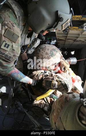 Us-Armee Kapitän Ryan Stanfield, ein Flug Krankenschwester zu Unternehmen C zugeordnet, 1. Allgemeine Unterstützung Aviation Battalion, 111 Aviation Regiment, Task Force Dragon, sichert ein deutscher Soldat auf einen HH-60M Black Hawk Hubschrauber während einer Koalition medevac und Hoist Training übung in Erbil, Irak, Nov. 20, 2016. Diese Schulung wurde durchgeführt, um zu lehren und zu Deutschen vertraut machen, Niederländische und Finnische Soldaten mit US-Armee medevac Ausrüstung und Verfahren. Mehr als 60 Koalitionspartner haben sich auf das Ziel der Beseitigung der Bedrohung durch den Islamischen Staat im Irak und der Levante verpflichtet und haben contr Stockfoto