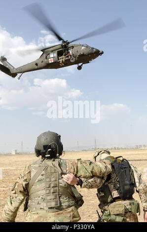 Us-Armee Sgt. Jorge Vasquez, ein Medic mit Unternehmen C, 1. Allgemeine Unterstützung Aviation Battalion, 111 Aviation Regiment, und eines deutschen Soldaten halten auf einander als HH-60M Black Hawk Hubschrauber Ansätze während medevac und Hoist Training in der Nähe von Erbil, Irak, Nov. 20, 2016. Dieses Training wurde die deutsche, die niederländische und die finnische Soldaten zur Verfügung stellt, um die Koalitionspartner mit US-Armee medevac Verfahren und Ausrüstung vertraut zu machen. Die 111 ist derzeit in der Unterstützung von Combined Joint Task Force - inhärenten Lösung bereitgestellt. (U.S. Armee Foto: Staff Sgt. Peter J. Berardi) Stockfoto
