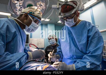 160823-N-CV 785-108 Padang, Indonesien (Aug. 23, 2016) U.S. Navy Hospital Corpsman 1. Klasse Valdivio Reid (links), von New York, unterstützt US Navy Lieutenant Cmdr. Eduardo Gomez, ein Chirurg aus Los Angeles, während eine zahnmedizinische Operation an Bord Hospital Ship USNS Mercy (T-AH 19), während der Pacific Partnerschaft 2016. Dies ist bereits das fünfte Mal, Pazifische Partnerschaft Indonesien besucht hat. Partner Nationen arbeiten Seite an Seite mit lokalen Organisationen während Disaster Response Training, Tiefbau, Frauen, Frieden und Sicherheit Seminare, medizinische Experten Austausch und eine Live Bereich Ausbildung e Stockfoto