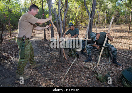 Australische Armee Sgt.. Dominic Hamon, Links, und der chinesischen Volksbefreiungsarmee Cpl. Kaijan Li, Mitte, und Leutnant Xianyu Yang graben Stöcken machen während der Ausbildungsphase der Übung Kowari, in der Daly River Region des Northern Territory gehalten zu werden, am 29. August 2016. Kowari ist eine australische Armee-gehostete überleben Fähigkeiten trainieren, die Zusammenarbeit im Bereich der Verteidigung zwischen den Truppen aus den USA, Australien und China zu erhöhen. (Australian Defence Force Foto von Cpl. Jake Sims) Stockfoto